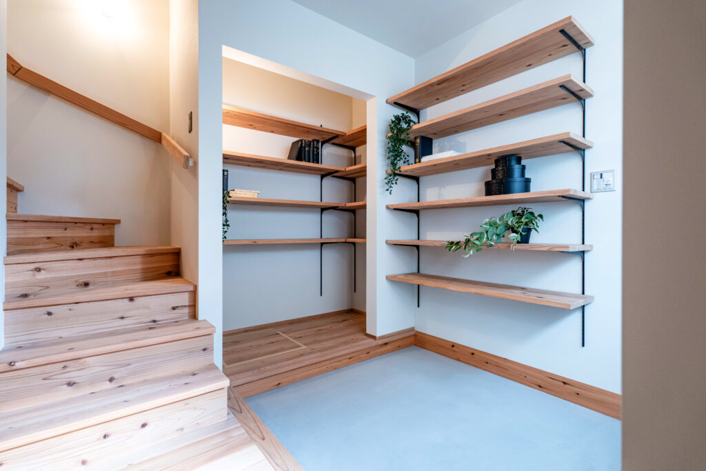 狭小住宅の玄関土間。可動棚と家族クローゼットが一体になった空間