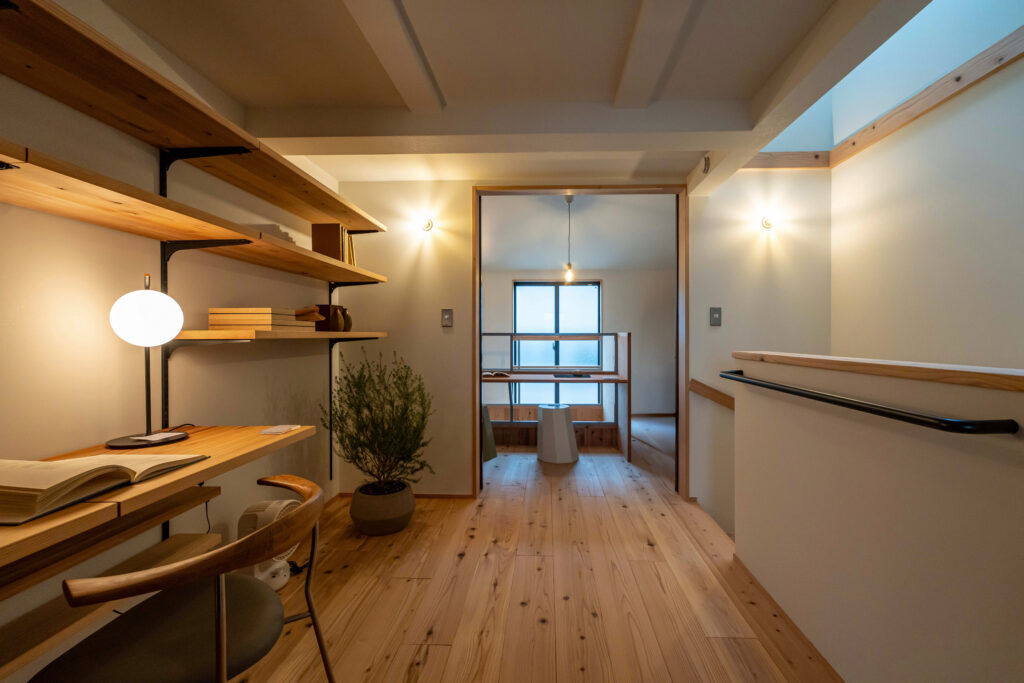 無垢杉の床の3階ホールに設けた造作デスクと可動棚（間口二間の狭小住宅・ヤマネコハウス）