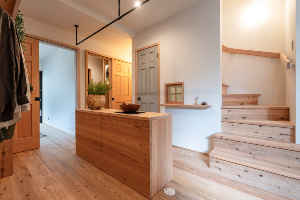 狭小住宅の玄関土間。可動棚と家族クローゼットが一体になった空間